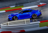 [Action] Traxxas 4-Tec Mustang - mavi araç bariyerli kapalı pistte yandan drift yaparken