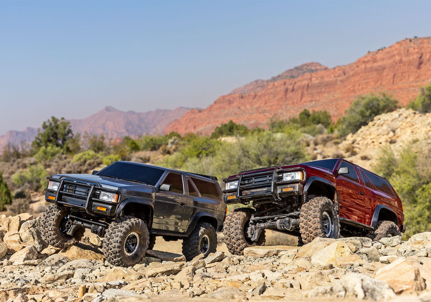 [Action] Traxxas TRX-4 Pathfinder - kırmızı ve gri iki araç kayalık arazide yan yana