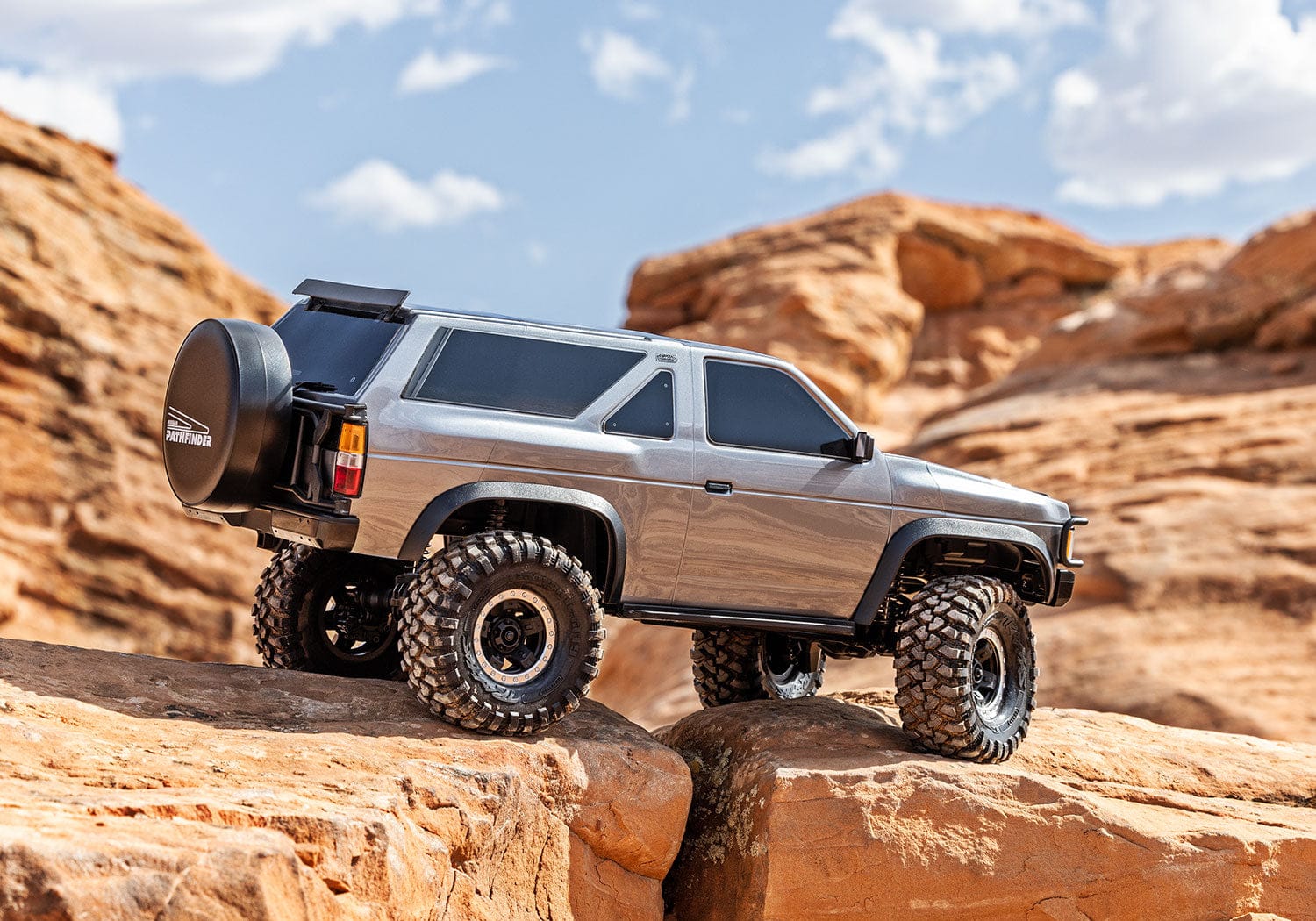 [Action] Traxxas TRX-4 Pathfinder - gri araç kırmızı kaya yamacını tırmanıyor önden görünüm