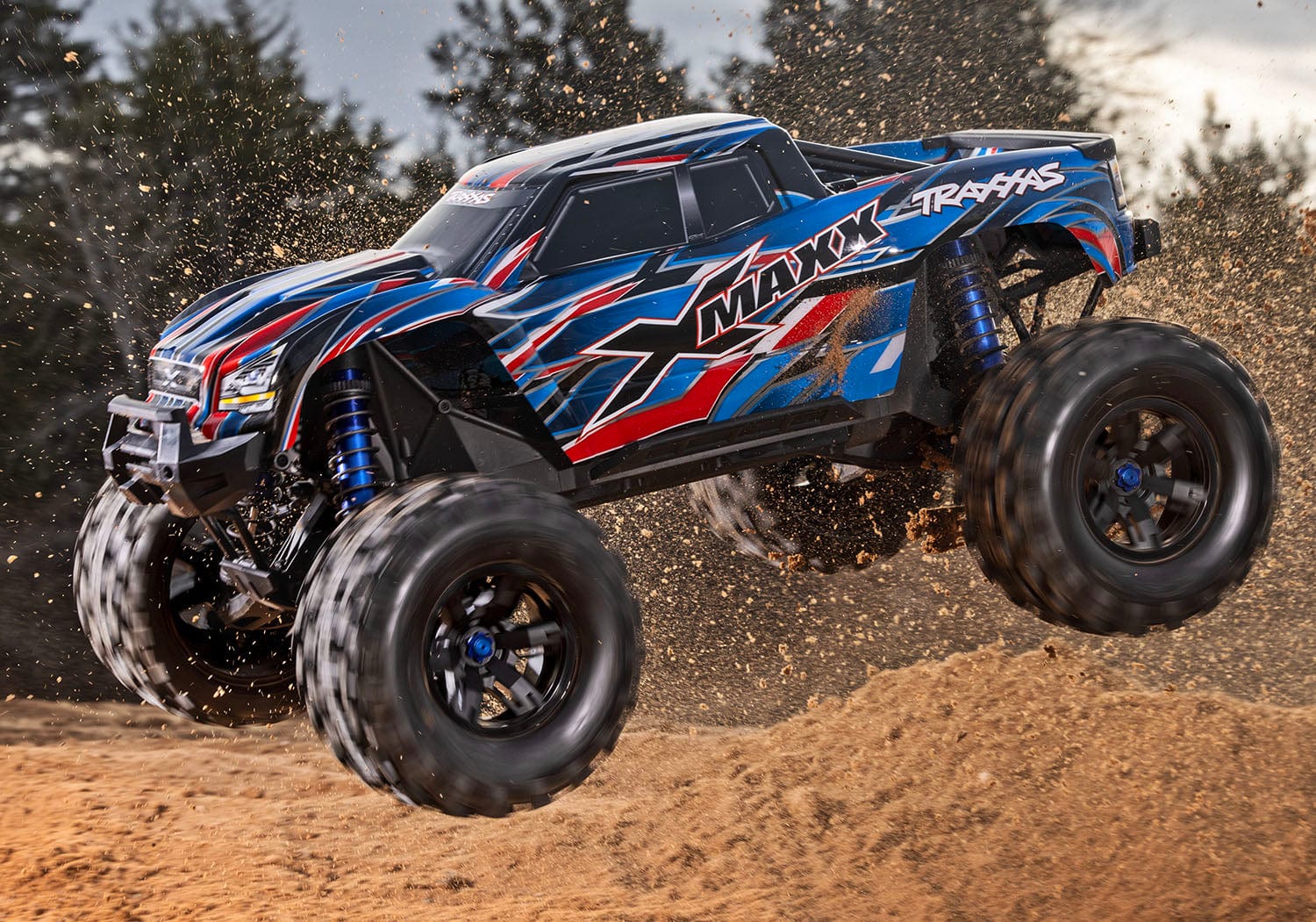 [Action] Traxxas X-Maxx Belted - mavi araç havada atlayış yaparken