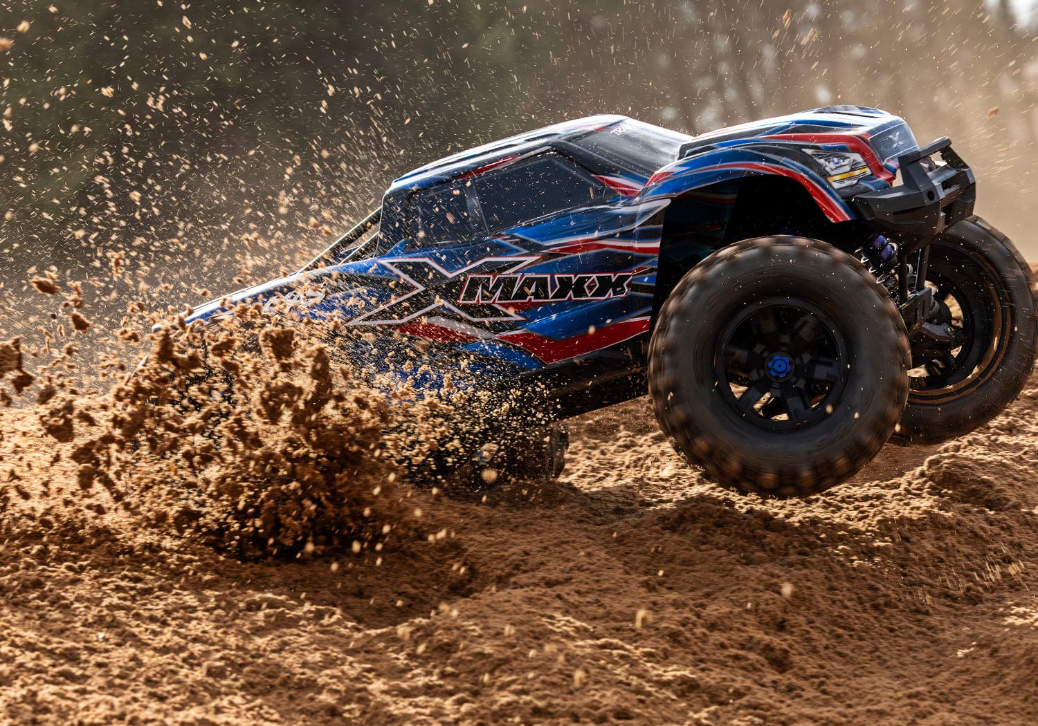 [Action] Traxxas X-Maxx Belted - mavi araç toprakta drift atarken