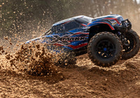 [Action] Traxxas X-Maxx Belted - mavi araç toprakta drift atarken