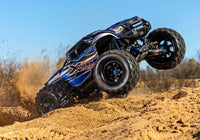 [Action] Traxxas X-Maxx - mavi araç kumda tek teker kalkışla viraj alırken