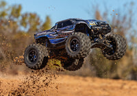 [Action] Traxxas X-Maxx - mavi araç havada zıplarken arazi atlayışı