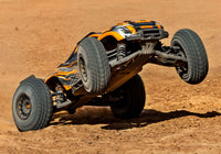[Action] Traxxas XRT 4WD - turuncu araç toprak pistte tek teker üstünde