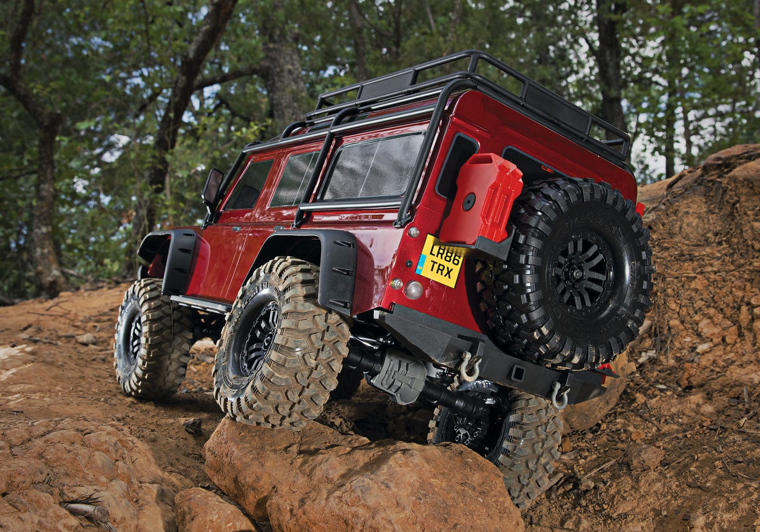 [Action] Traxxas TRX-4 Defender Combo - Kırmızı Defender ormanda kayalık tırmanışta arkadan yedek bidon