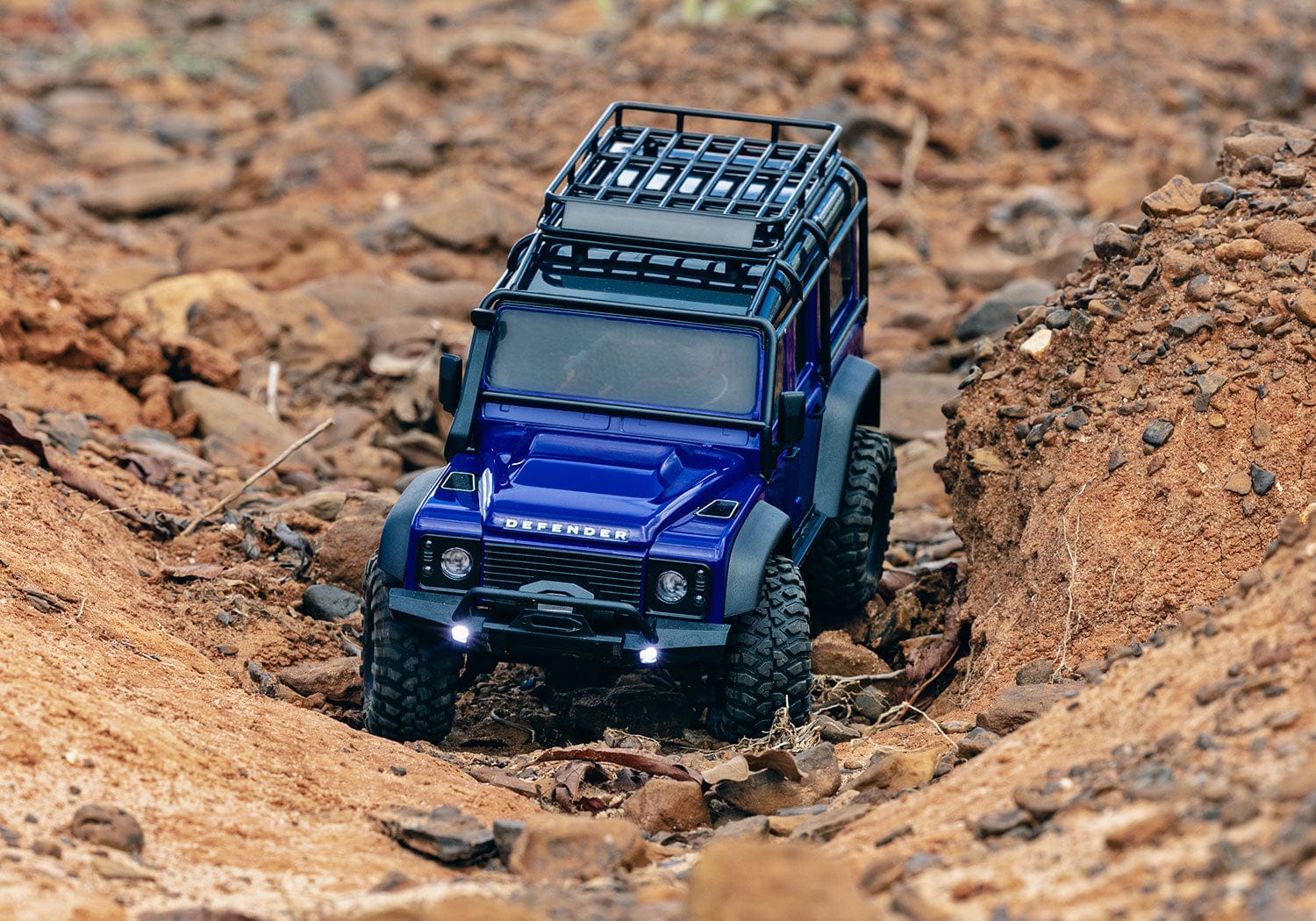 [Action] Traxxas TRX-4M Defender - turuncu araç su kenarı kayalarında