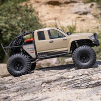 [Action] Axial SCX6 Trail Honcho - kum rengi araç kayalık arazide yandan görünüm