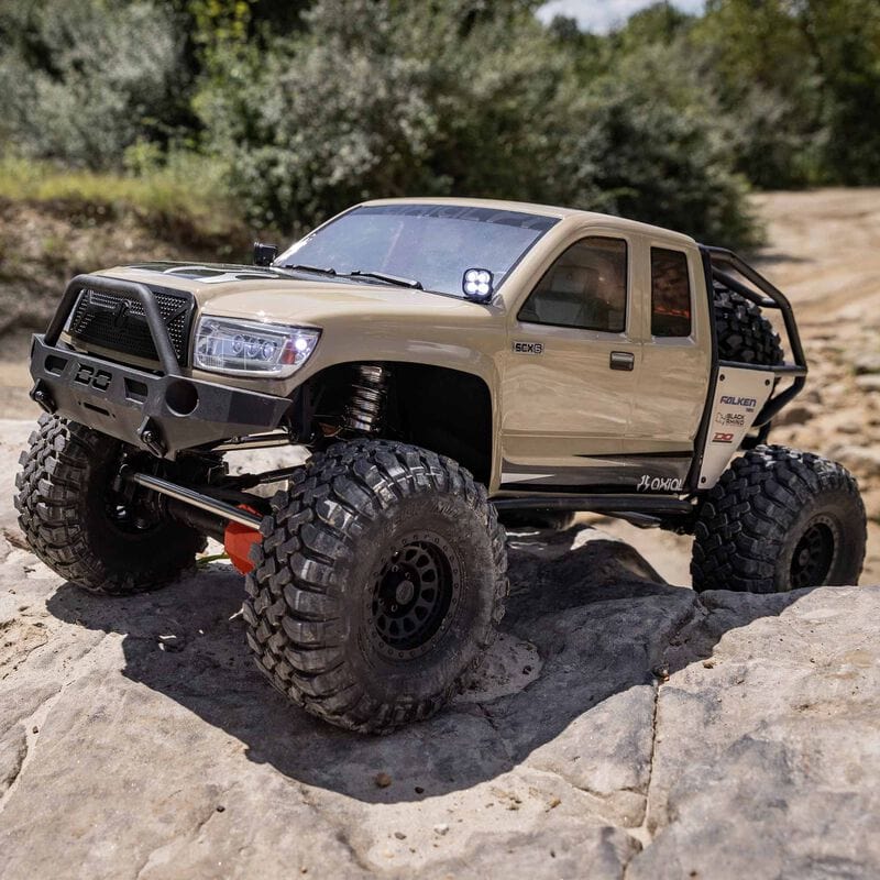 [Action] Axial SCX6 Trail Honcho - kum rengi araç taşlı patikada ön çapraz görünüm