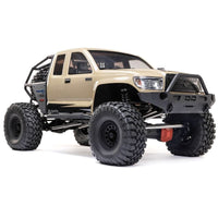 [Dış] Axial SCX6 Trail Honcho - kum rengi araç stüdyo ön çapraz görünüm, kaya kafesi ve tampon