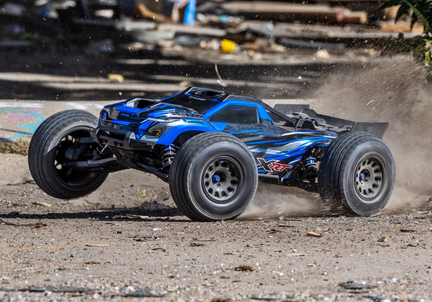 [Action] Traxxas XRT 4WD - mavi araç arazide kayarak enkaz püskürtüyor