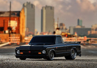 [Action] Traxxas Drag Slash - siyah araç önden, şehir silüeti arkaplanı